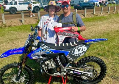 Josh Stevenson of PPI hands Grant a sponsor check at Redbud 2025.